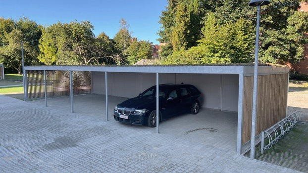 UNA carportanlæg med beklædning i lodrette lameller og sedum på taget