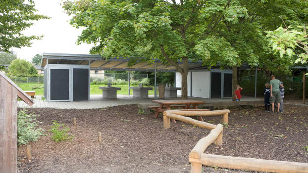 Stor overdækning til undervisning. Opbevaringsrum placeret i begge ender. Tagpap på taget