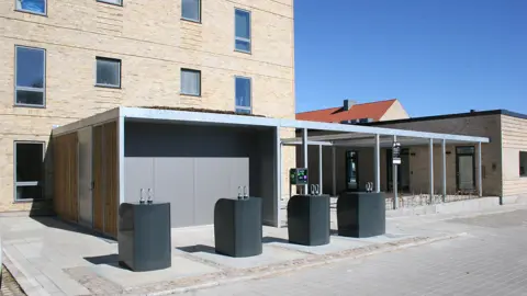 Multioverdækning forener cykelværksted, pergola og overdækket terrasse under ét tag.