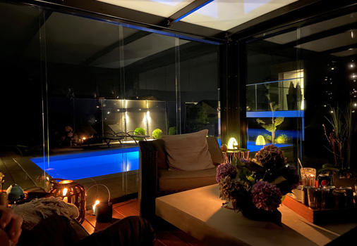 Aftenstemning i udestuen med glassider og udsigt til pool
