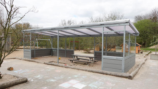 Overdækning med beklædning i komposit/hærdet glas. Her kan børnene lege i al slags vejr