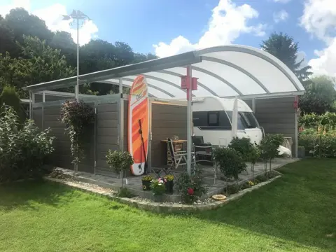Carport med skur, overdækning og plads til campingvogn