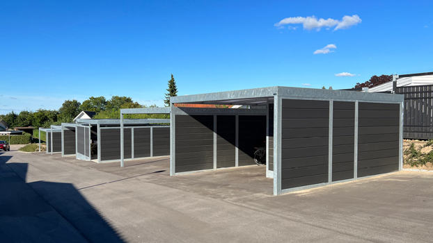 UNA carporte med tilhørende redskabsrum i meget kuperet terræn